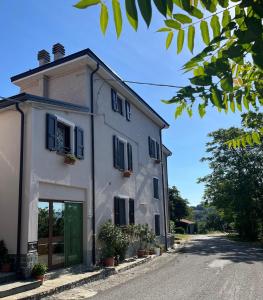 a white building with black shutters on a street at Casa da Antonia 850 ASL in Ronchi
