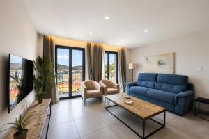 a living room with a blue couch and a table at Apartamentos Turísticos Puerta Real by CartagenaSpain in Cartagena