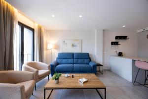 a living room with a blue couch and a table at Apartamentos Turísticos Puerta Real by CartagenaSpain in Cartagena +52 photos
