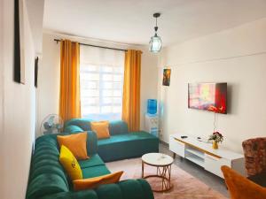 a living room with a green couch and a tv at 1&2&3bedroom KlenCBDMilimani apartments in Kisumu