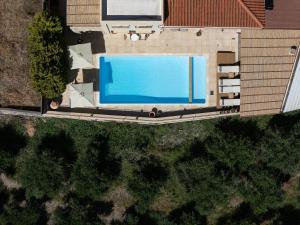 an overhead view of a swimming pool next to a house at Ilys Home, a Country-chic Retreat with Pool & BBQ, By ThinkVilla in Margarítai