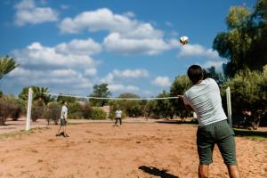 a group of men playing a game of volleyball at Barceló Palmeraie Oasis Resort in Marrakesh