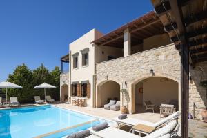 a villa with a swimming pool and a house at Ilys Home, a Country-chic Retreat with Pool & BBQ, By ThinkVilla in Margarítai