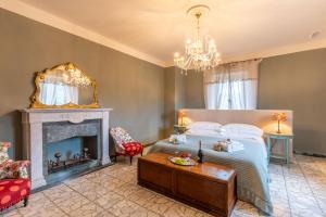 a bedroom with a bed and a fireplace and a chandelier at La Rocca di Camporgiano in Camporgiano