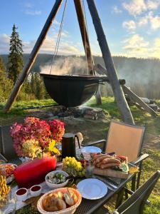 a picnic table with food on it with a grill at Tatra Glamp Bukowina Tatrzańska - Sieć noclegowa Tatra Glamp in Bukowina Tatrzańska