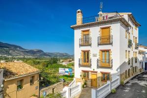 a white building with orange doors and balconies on a street at Carrebaix Loft in Orba