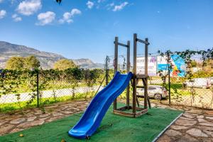 a playground with a blue slide in front of a fence at Carrebaix Loft in Orba