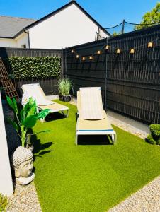a yard with two lounge chairs on the grass at Spa love room in Donges +16 photos