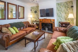 a living room with leather couches and a fireplace at Hudson House in Durham
