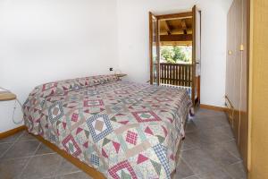 a bedroom with a bed with a quilt on it at Fausta Lago in Colico