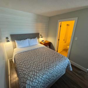 a bedroom with a large bed and a yellow door at Motel Brise Marine in Shippagan