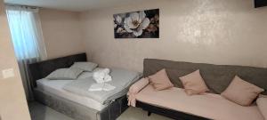 a living room with a couch and a flower picture on the wall at Mini wellness studio-near the airport in Smlednik