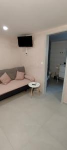 a living room with a couch and a table at Mini wellness studio-near the airport in Smlednik