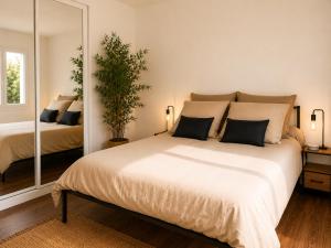 a bedroom with a large bed and a mirror at Les Lavandes de Vals in Vals-les-Bains