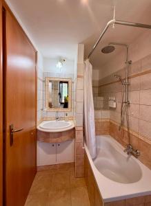 a bathroom with a tub and a sink at Via Roma 40 - apartment in Pacentro +20 photos