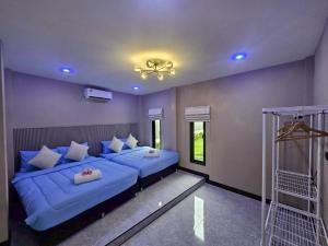 a bedroom with two blue beds in a room at 185 HomeStay Chiangmai 185 โฮมสเตย์ เชียงใหม่ in Hang Dong