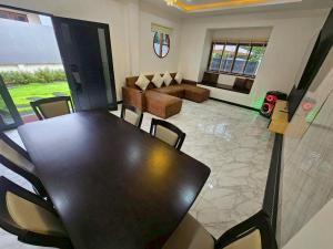 a dining room with a table and a couch at 185 HomeStay Chiangmai 185 โฮมสเตย์ เชียงใหม่ in Hang Dong