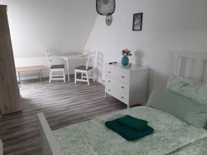 a bedroom with a bed and a dresser and a desk at Fewo-Am-Tanger in Tangerhütte