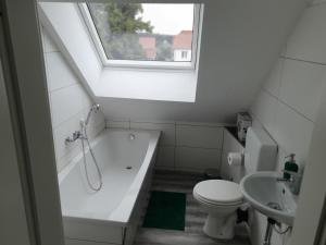 a bathroom with a tub and a toilet and a window at Fewo-Am-Tanger in Tangerhütte