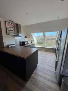 a kitchen with a large counter top in a room at Appartement spacieux au domaine in Coust