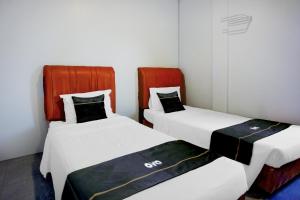 two beds sitting next to each other in a room at Collection O Banda Aceh near Masjid Raya Baiturrahman formerly Hotel Mulana in Banda Aceh