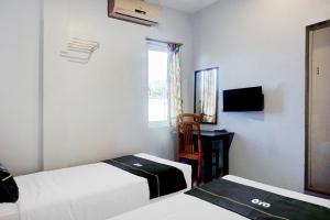 a room with two beds and a mirror and a window at Collection O Banda Aceh near Masjid Raya Baiturrahman formerly Hotel Mulana in Banda Aceh