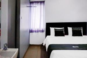 a hotel room with two beds and a sink at Collection O Banda Aceh near Masjid Raya Baiturrahman formerly Hotel Mulana in Banda Aceh
