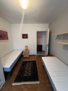 a room with two beds and a rug at Casa Balzarini- Vecchio Mulino in Entracque