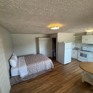 a bedroom with a bed and a kitchen with a table at Motel Brise Marine in Shippagan +7 photos