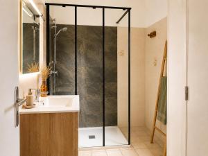 a bathroom with a shower and a sink at Les Lavandes de Vals in Vals-les-Bains