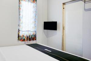 a room with a bed with a window and a tv at Collection O Banda Aceh near Masjid Raya Baiturrahman formerly Hotel Mulana in Banda Aceh +32 photos
