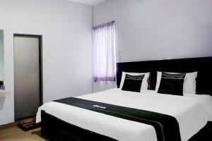 a bedroom with a large bed with white sheets and pillows at Collection O Banda Aceh near Masjid Raya Baiturrahman formerly Hotel Mulana in Banda Aceh