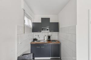 a small kitchen with a sink and a microwave at NM living Lünen VII in Lünen