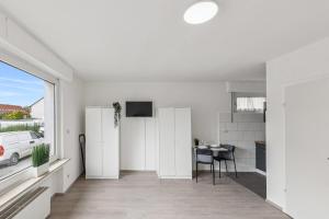 a white living room with a table and a window at NM living Lünen VII in Lünen
