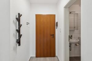 a wooden door in a bathroom with a sink at NM living Lünen VII in Lünen