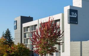 a building with a tree in front of it at Hotel 116, A Coast Hotel Bellevue in Bellevue