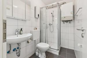 a bathroom with a toilet and a sink and a shower at NM living Lünen VII in Lünen