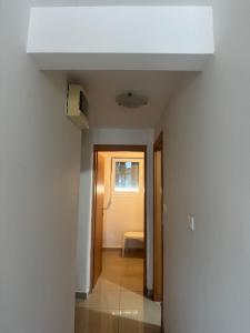 an empty room with a white ceiling and a hallway at Astra Apartment in Meljine