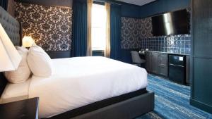 a hotel room with a bed and a kitchen at Midnight Sun, a Coast Hotel in Dawson City