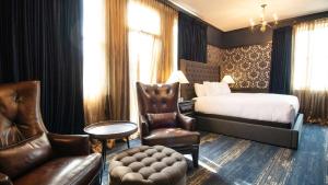 a hotel room with a bed and a chair at Midnight Sun, a Coast Hotel in Dawson City