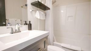a white bathroom with a sink and a toilet at Midnight Sun, a Coast Hotel in Dawson City +58 photos
