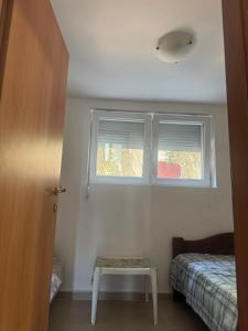 a small bedroom with a bed and a window at Astra Apartment in Meljine