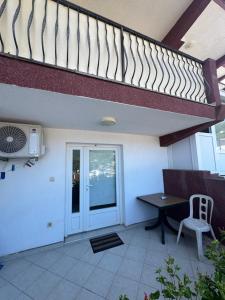 a balcony with a table and a staircase at Astra Apartment in Meljine
