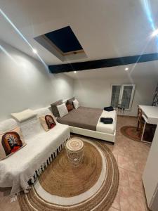 a bedroom with a bed and a couch and a table at Maison cosy 5 pers 2 suites parentales Proche Mer& Narbonne in Coursan