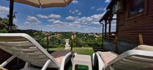 a group of chairs and an umbrella on a porch at Vikendica Monte in Ledinci