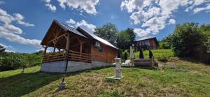 a small cabin in a field with a house at Vikendica Monte in Ledinci