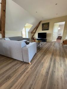 a living room with a couch and a television at Appartement spacieux au domaine in Coust