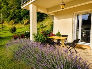 a patio with a table and chairs and flowers at Les Lavandes de Vals in Vals-les-Bains