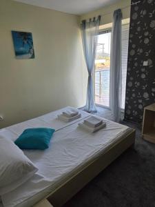 a bedroom with a large white bed with a window at The Yellow House in Ahtopol