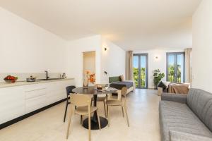 a kitchen and living room with a table and a couch at Via Tirso Rooms & Studio in Tortolì